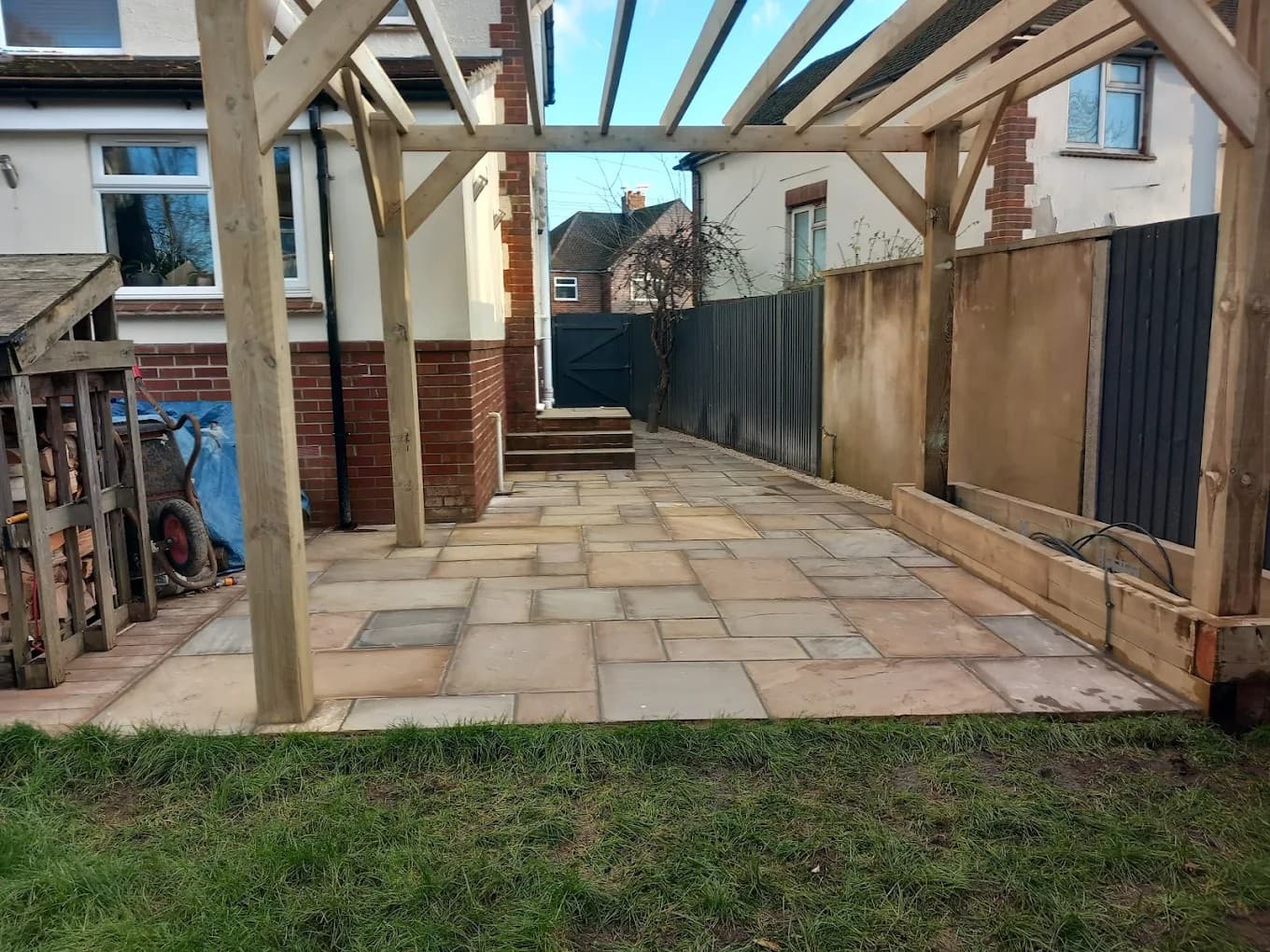 Garden pergola installed over premium stone paving, creating a stylish outdoor entertainment and dining area.